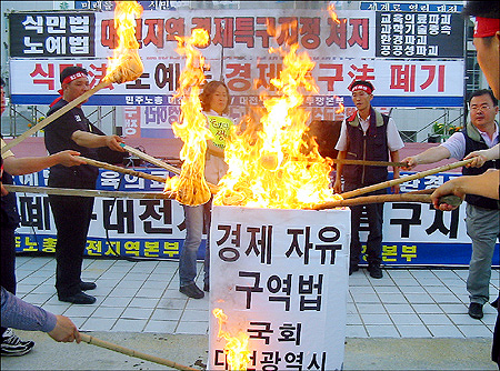 28일 오후4시부터 대전시청 남문광장에서 진행된 '경제자유구역법 폐기, 대전지역 경제특구지정 저지' 1차 총력집회. 사진은 경제자유구역법의 악법 조항이 적힌 현수막을 화형식하는 장면. 